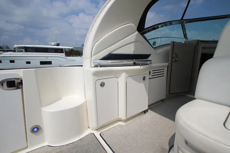 Slide: The Image of 2004 Sea Ray 40 Sundancer yacht interior with seating and storage, under a clear sky. - 10