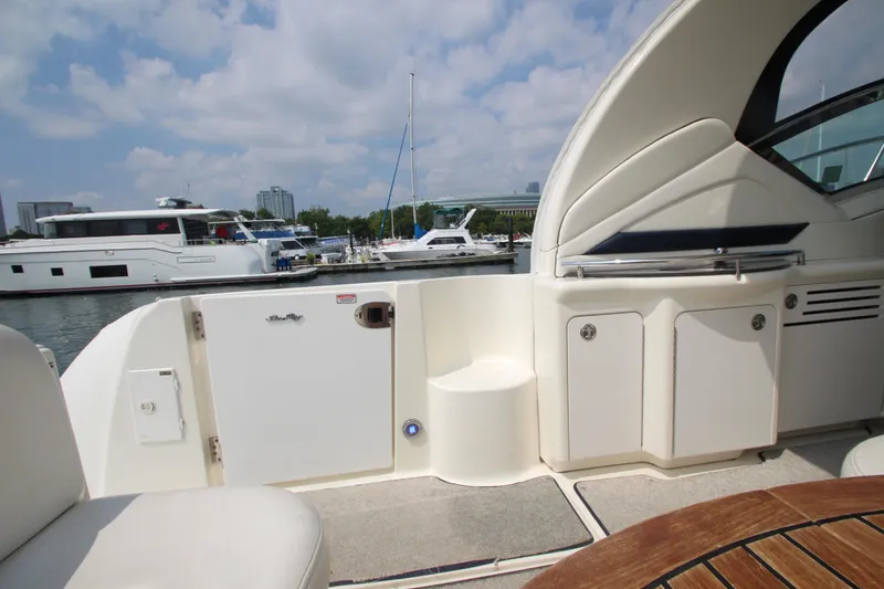 Slide: The Image of 2004 Sea Ray 40 Sundancer yacht interior with marina view, featuring seating and storage. - 11
