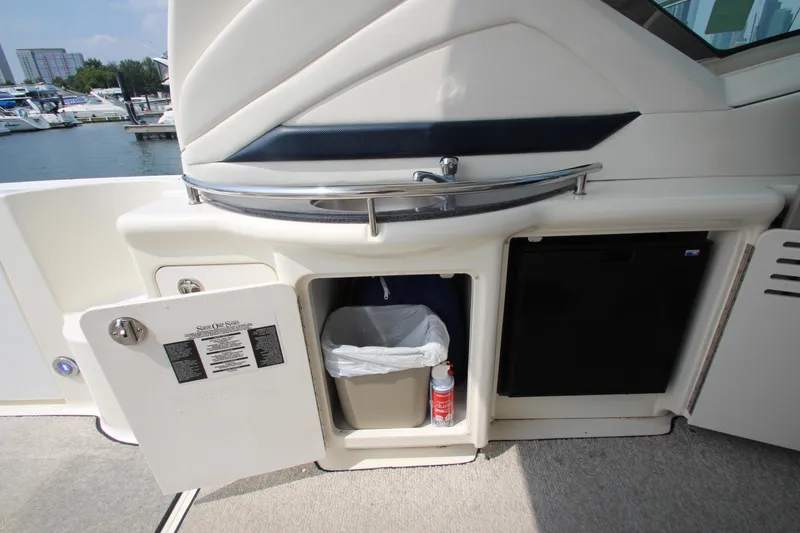 Slide: The Image of 2004 Sea Ray 40 Sundancer yacht interior with open storage compartment and mini fridge. - 12