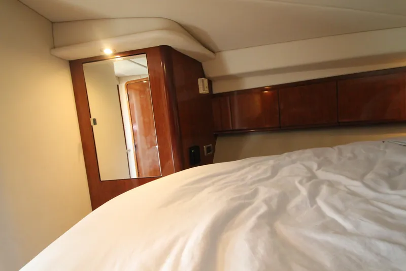 Slide: The Image of Interior cabin of 2004 Sea Ray 40 Sundancer yacht with wooden cabinetry and bed. - 45