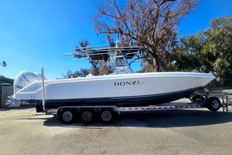 Slide: The Image of 2006 Donzi 32 ZF boat on trailer, parked outdoors under clear blue sky. - 1