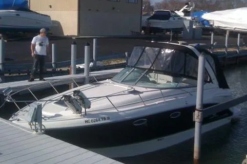 The Image of 2006 Chaparral Signature 310 boat docked at a marina with a person nearby. - 1