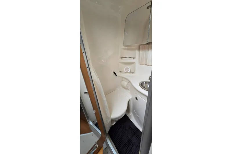 Slide: The Image of Compact bathroom in 2006 Chaparral Signature 310 boat, featuring toilet and sink. - 26