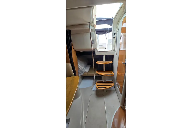 Slide: The Image of Interior of 2006 Chaparral Signature 310 boat, featuring wooden steps and cozy cabin space. - 28