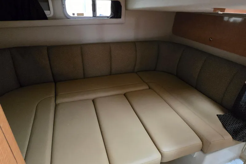 Slide: The Image of 2006 Chaparral Signature 310 cabin interior with beige seating and window. - 30