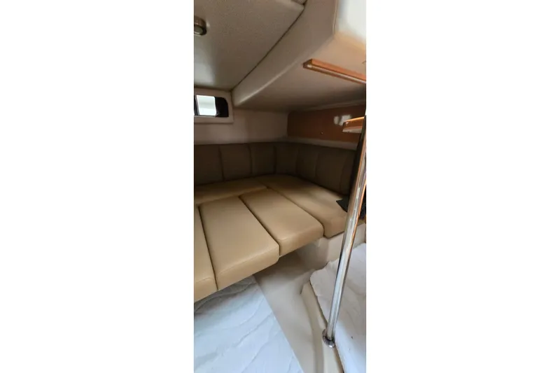 Slide: The Image of 2006 Chaparral Signature 310 cabin interior with beige seating and compact design. - 32