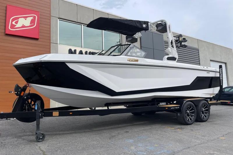 Slide: The Image of 2026 Nautique Super Air Nautique GS24 boat on trailer outside dealership. - 2