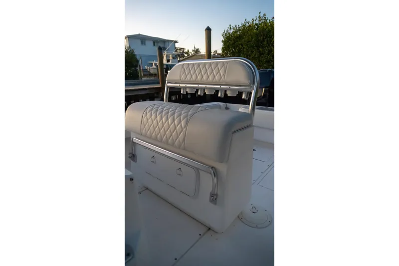 Slide: The Image of Contender 27 Tournament 2005 boat seat with rod holders and storage, docked at sunset. - 11