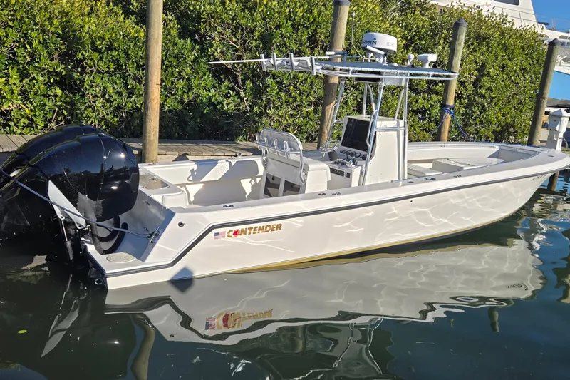 Slide: The Image of 2005 Contender 27 Tournament boat docked, featuring sleek design and powerful outboard engines. - 2
