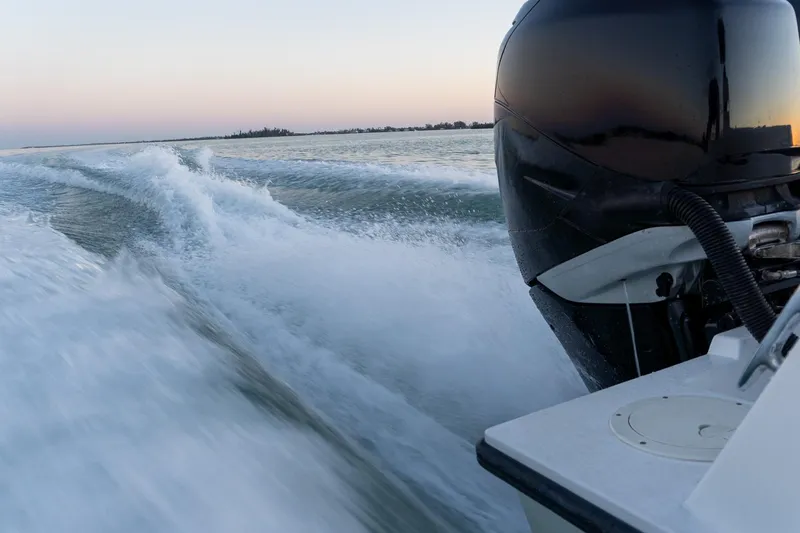 Slide: The Image of Outboard motor of 2005 Contender 27 Tournament boat creating waves at sunset. - 21
