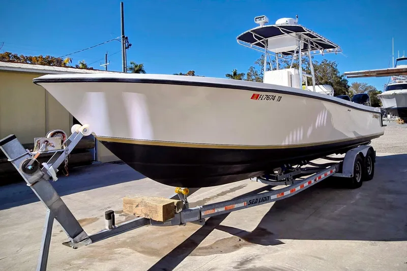 Slide: The Image of 2005 Contender 27 Tournament boat on trailer, parked outdoors under clear blue sky. - 38