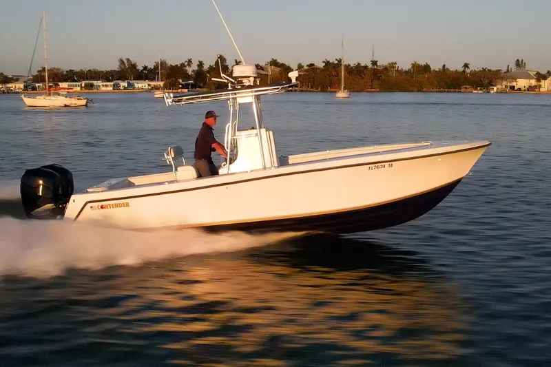 Slide: The Image of 2005 Contender 27 Tournament boat cruising on calm water at sunset. - 7