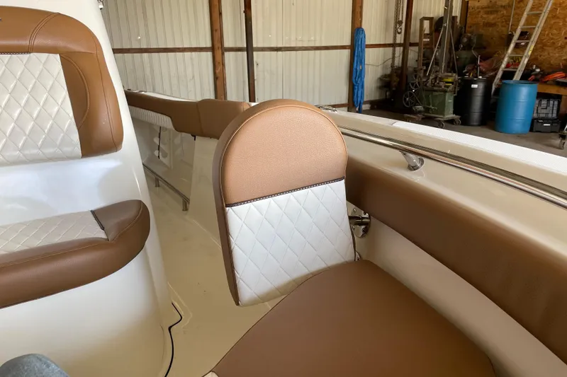 Slide: The Image of 2026 Pioneer 202 Islander boat interior with brown and white cushioned seating. - 14