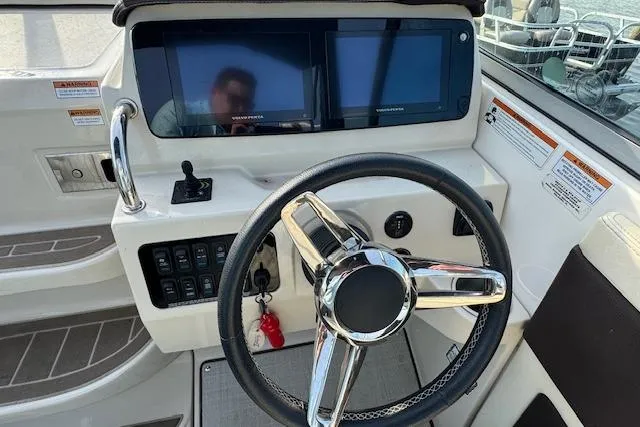 Slide: The Image of 2023 Regal 28 Express boat helm with dual screens and modern steering wheel. - 18