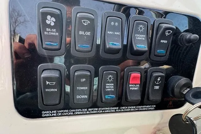 Slide: The Image of Control panel of a 2023 Regal 28 Express boat with various switches and keys. - 19