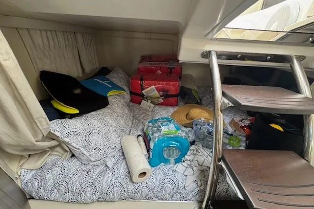 Slide: The Image of 2023 Regal 28 Express cabin interior with bedding, supplies, and a ladder. - 29