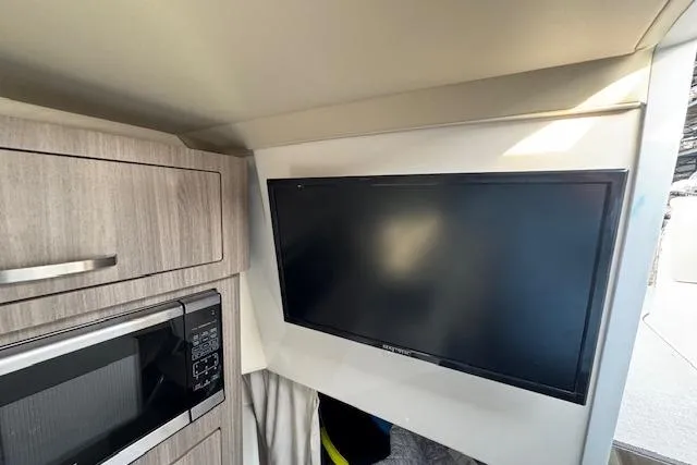 Slide: The Image of 2023 Regal 28 Express interior with TV and microwave in modern cabinetry. - 30