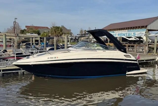 Slide: The Image of 2023 Regal 28 Express boat docked at marina, calm water, clear sky. - 5
