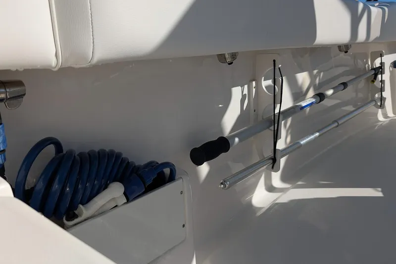 Slide: The Image of 2023 Key West 239 FS boat interior with fishing rod holders and coiled hose. - 11