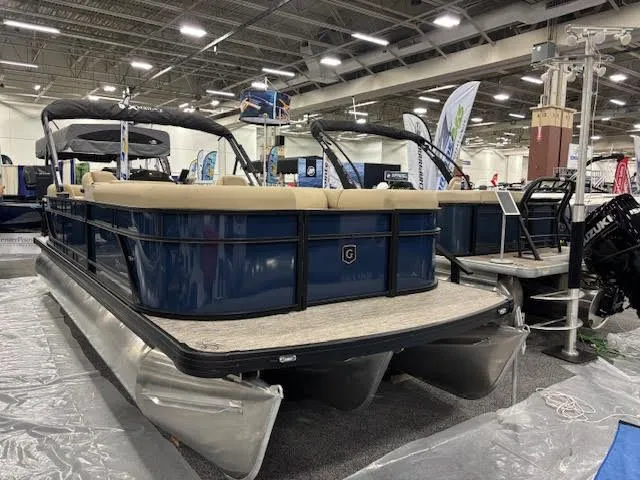 The Image of 2026 Godfrey EX2286SBX pontoon boat displayed at a trade show. - 0
