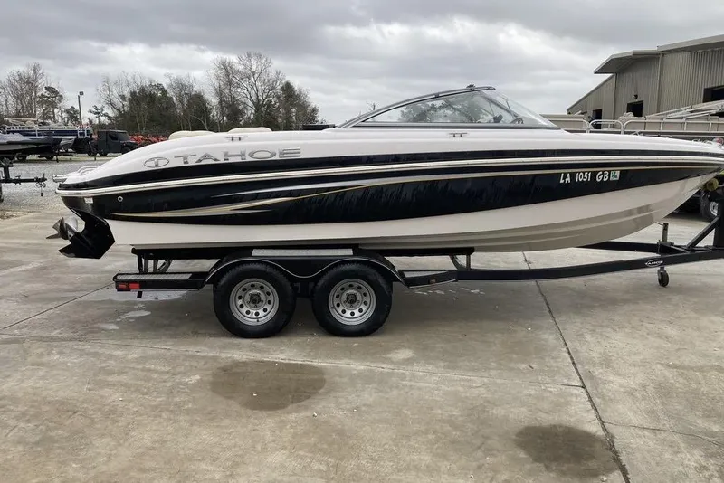The Image of 2012 Tahoe Q8 SSi boat on trailer, parked outdoors on a cloudy day. - 0