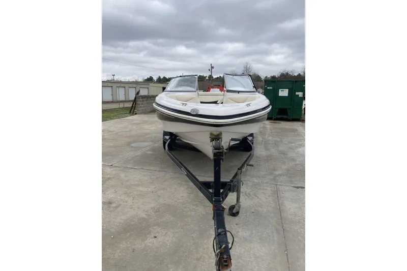Slide: The Image of 2012 Tahoe Q8 SSi boat on trailer, parked outdoors under cloudy skies. - 2
