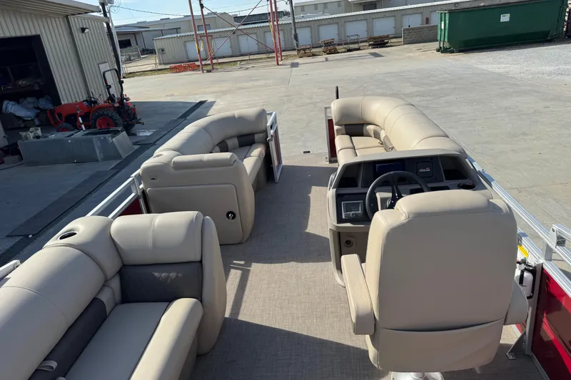 Slide: The Image of 2024 Sun Tracker Party Barge 20 DLX interior with beige seating and steering console. - 9