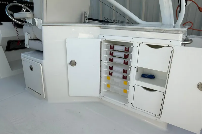 Slide: The Image of 2024 World Cat 280 DC-X boat interior with storage compartments and steering wheel. - 25