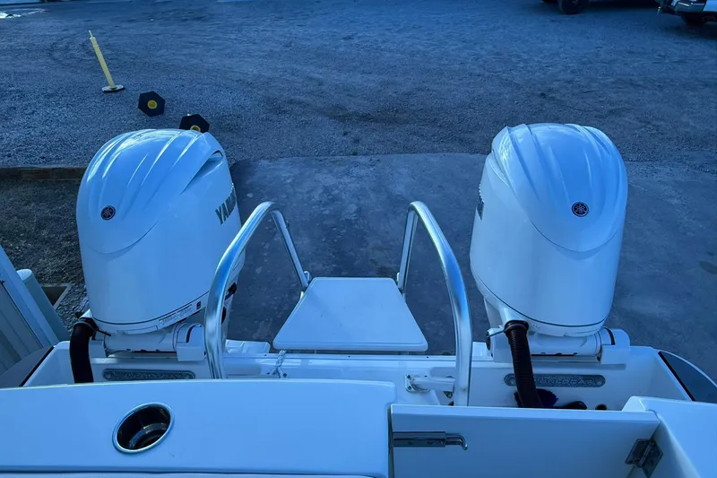 Slide: The Image of 2024 World Cat 280 DC-X boat with dual Yamaha outboard engines, docked on gravel. - 28