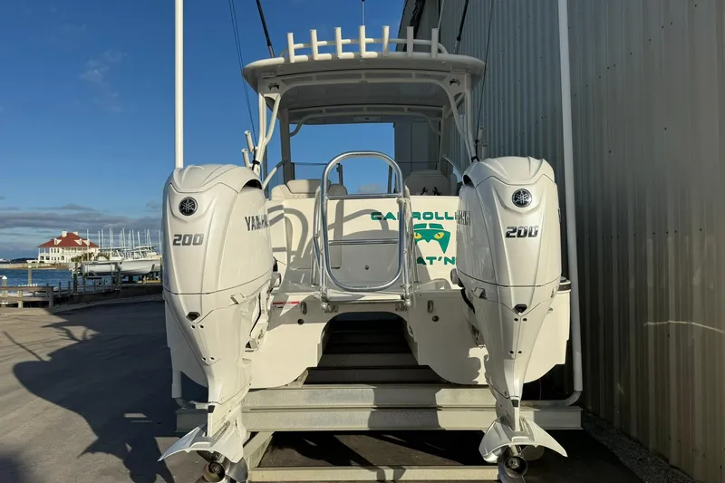 Slide: The Image of 2024 World Cat 280 DC-X boat with twin Yamaha 200 engines docked by a marina. - 5