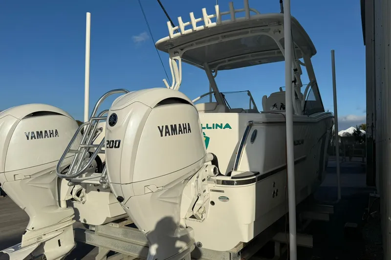 Slide: The Image of 2024 World Cat 280 DC-X boat with dual Yamaha 200 engines, docked under clear sky. - 6
