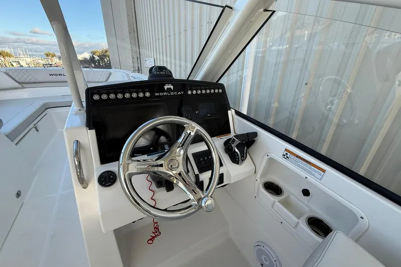 Slide: The Image of 2024 World Cat 280 DC-X boat helm with steering wheel and control panel. - 8