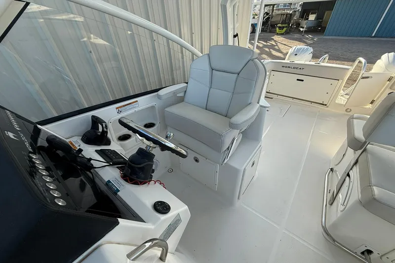 Slide: The Image of 2024 World Cat 280 DC-X boat interior with helm, seating, and controls. - 9