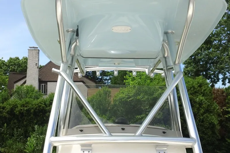 Slide: The Image of 2026 Pioneer 222 Islander boat with sleek metal framework and canopy, set against lush greenery. - 17