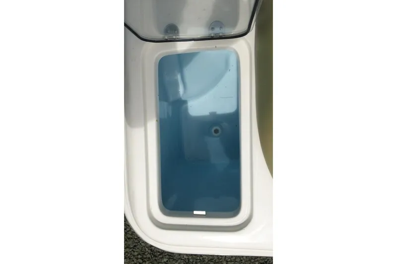 Slide: The Image of Livewell compartment of 2026 Pioneer 222 Islander boat, featuring a clear lid and blue interior. - 20
