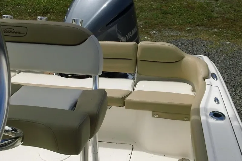 Slide: The Image of 2026 Pioneer 222 Islander boat interior with beige seating and Yamaha engine. - 22