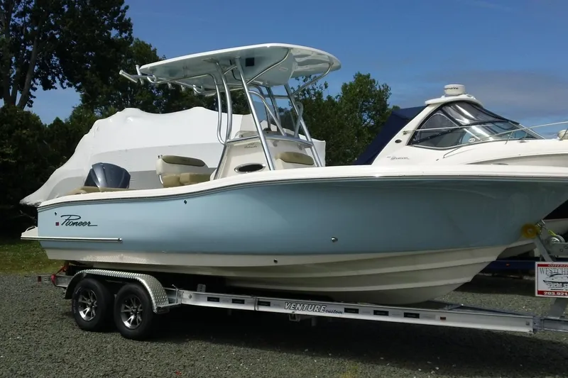 Slide: The Image of 2026 Pioneer 222 Islander boat on trailer, light blue hull, parked outdoors. - 3