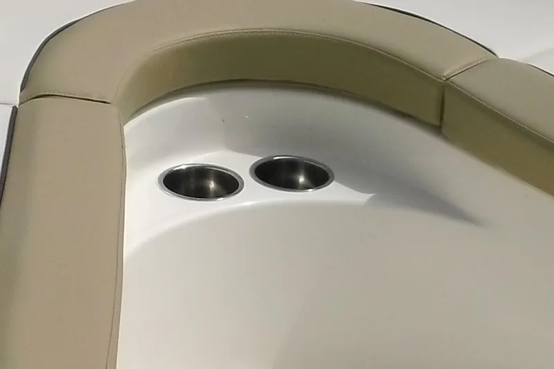 Slide: The Image of Pioneer 222 Islander 2026 boat interior with beige seating and dual cup holders. - 9