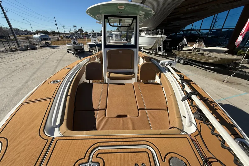 Slide: The Image of 2024 Sea Hunt Gamefish 27 boat with tan deck, parked outdoors. - 10
