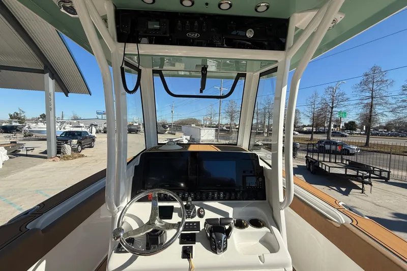 Slide: The Image of 2024 Sea Hunt Gamefish 27 boat cockpit with steering wheel and control panel. - 13