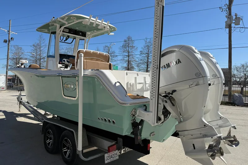 Slide: The Image of 2024 Sea Hunt Gamefish 27 boat with dual Yamaha engines on a trailer. - 4