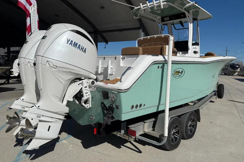 Slide: The Image of 2024 Sea Hunt Gamefish 27 boat with dual Yamaha engines on a trailer. - 6