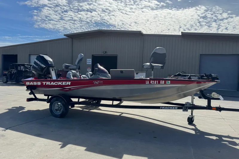 The Image of 2013 Tracker Pro Team 175 TXW bass boat on trailer, parked outdoors. - 0
