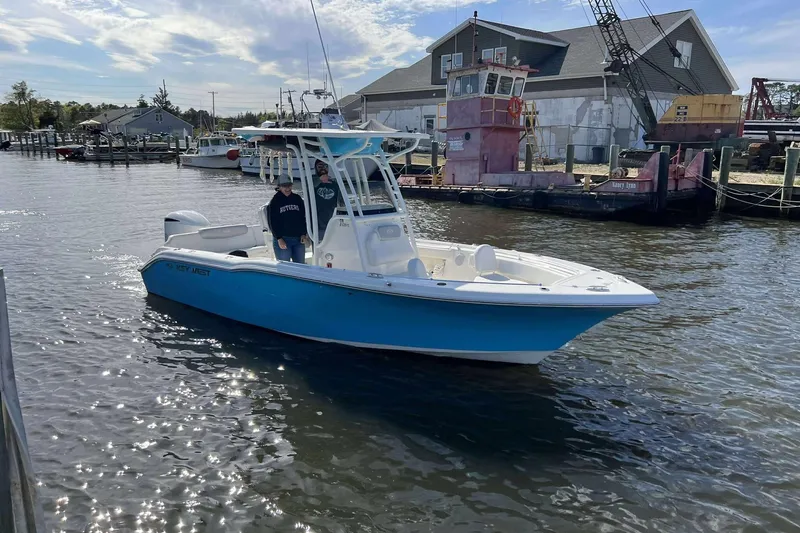 Slide: The Image of 2022 Key West 239 FS boat on water near dock, sunny day, two people onboard. - 3