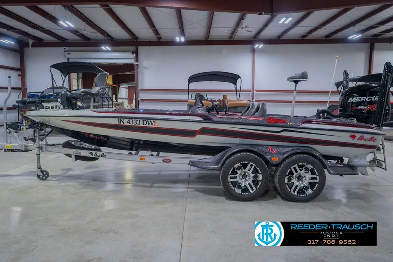 Slide: The Image of 2016 Bass Cat Cougar boat in showroom, featuring sleek design and dual-axle trailer. - 10