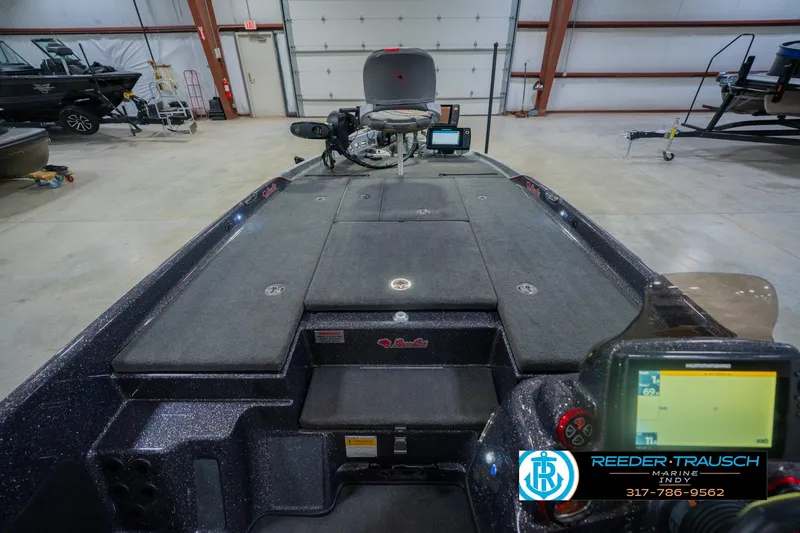 Slide: The Image of 2016 Bass Cat Cougar boat interior with navigation equipment in a garage setting. - 16