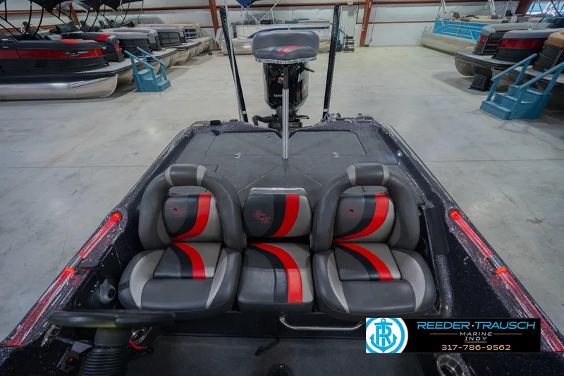 Slide: The Image of 2016 Bass Cat Cougar boat interior with red and gray seats in a showroom. - 20