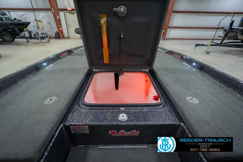 Slide: The Image of 2016 Bass Cat Cougar boat interior with open storage compartment, illuminated in red light. - 26
