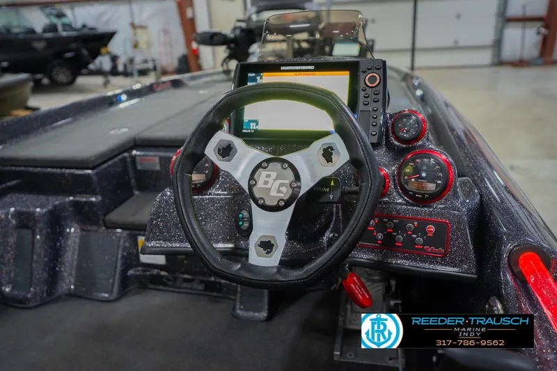 Slide: The Image of 2016 Bass Cat Cougar boat dashboard with steering wheel and electronic controls. - 28