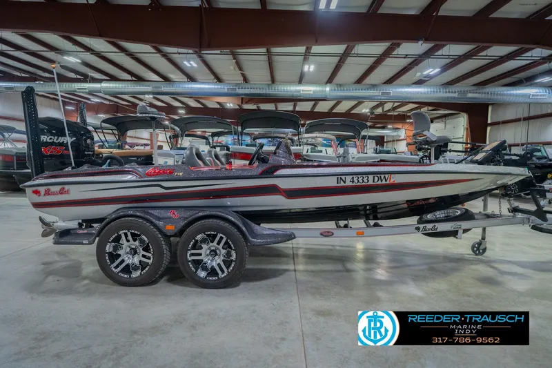 Slide: The Image of 2016 Bass Cat Cougar boat in showroom, featuring sleek design and dual-axle trailer. - 6